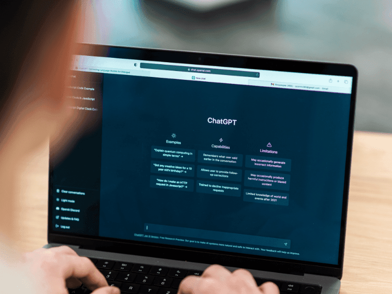 Person using ChatGPT on a laptop to explore remote AI job opportunities and learn how to earn money with AI
