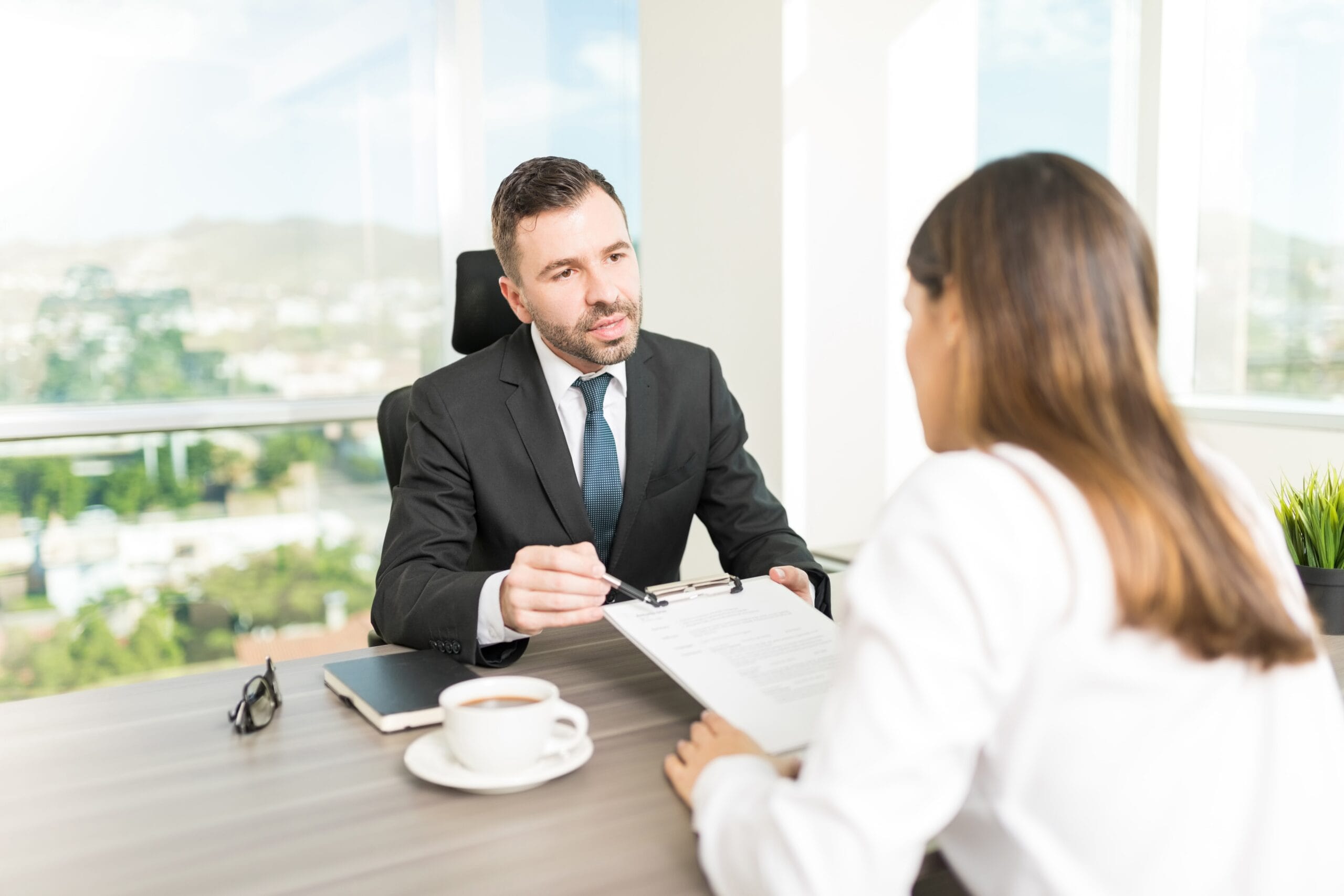 A professional job interview between a hiring manager and a candidate, highlighting the importance of resumes and how an AI resume generator free can help job seekers prepare instantly.