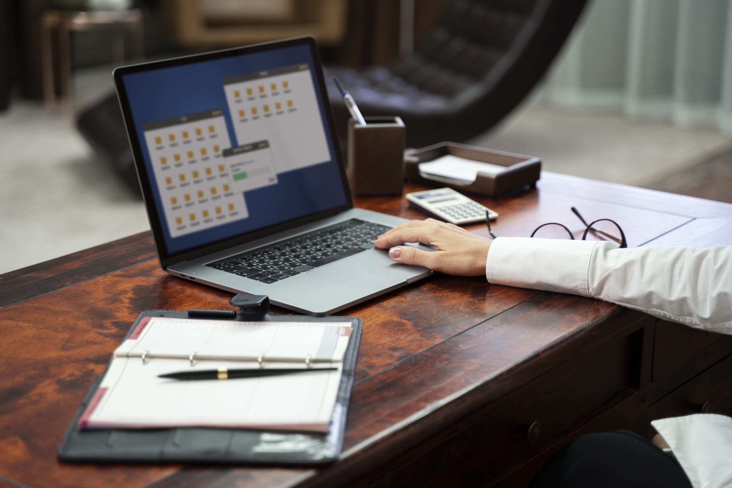 A professional managing job applications and organizing folders on a laptop, using the Best AI for Resume Reddit users recommend for multitasking and job tracking like Teal HQ.